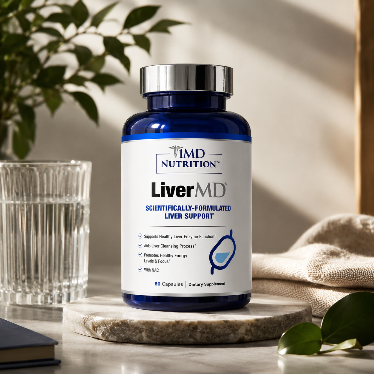 A bottle of Advanced Liver Support Capsules dietary supplement, set on a marble coaster next to a glass of water and a beige cloth, with soft-focus green leaves in the background.