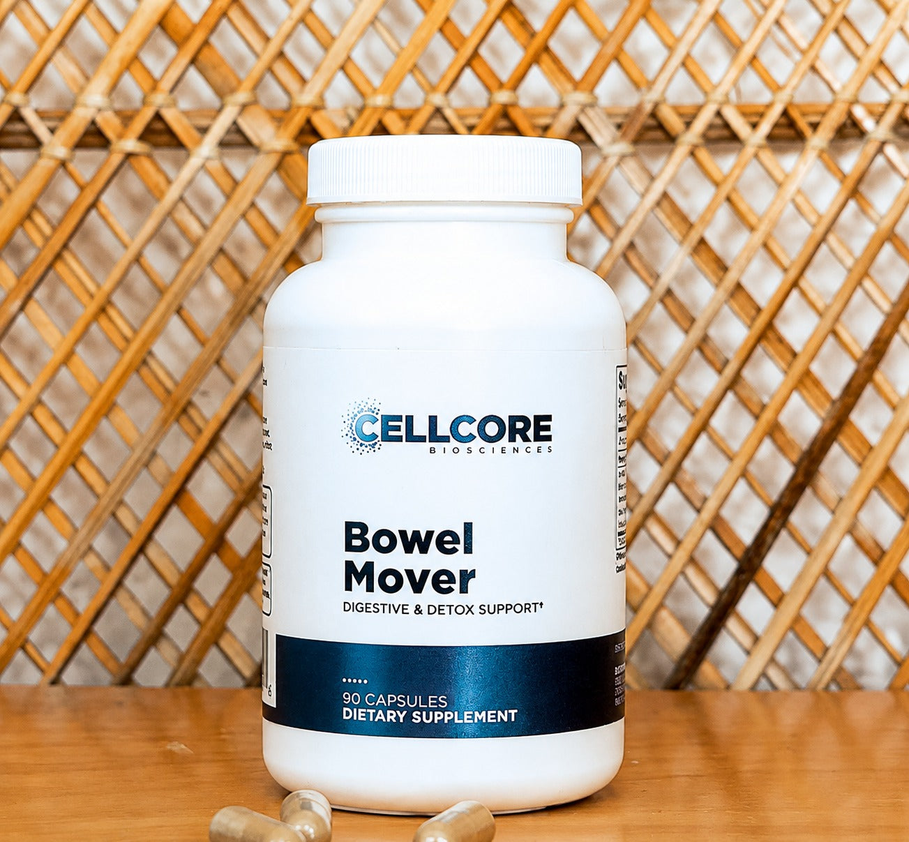 A white bottle of 'Bowel Mover' dietary supplement capsules, placed on a wooden surface with a wooden lattice background.